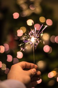 hand holding a sparkler against a bokeh background, illustrating new year's resolutions
