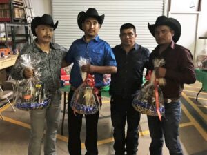 Four men holding gift baskets at a company gathering